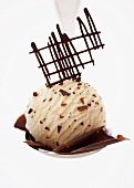 A scoop of stracciatella ice cream with chocolate flakes