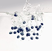 Blueberries falling into water
