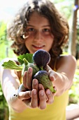 Young woman holding fresh figs in her hands