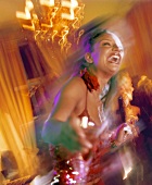 Junge Frau tanzt fröhlich mit Cocktail in der Hand
