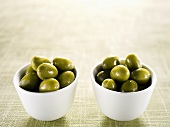 Two small bowls of green olives
