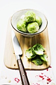 Brussels sprouts on chopping board with knife