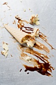 Remains of cone of nut ice cream with chocolate sauce
