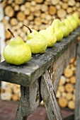 Fresh pears in a row on a wooden structure