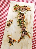 Pizza in the shape of the map of Italy on chopping board