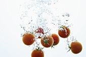 Tomatoes falling into water