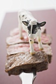 Steakscheiben und Rinderfigur auf Fleischgabel (Garstufen)