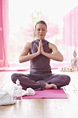 Woman in lotus position with bottle of water
