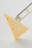 Piece of Emmental cheese on the point of a knife