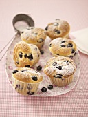 Six blueberry muffins with icing sugar