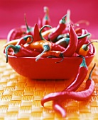 Red and orange chillies in a red bowl