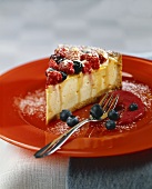 A piece of berry cheesecake with berry sauce