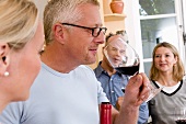Man tasting red wine while cooking