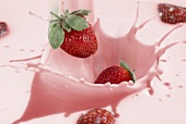 Strawberries falling into strawberry milk (full-frame)