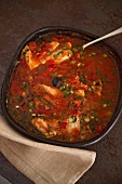 Cod with olives and spring onions in pepper sauce