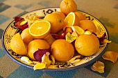 Oranges and rose petals in a bowl