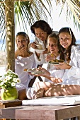 Mother and daughters with snacks on the beach