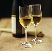 Two glasses of white wine and white wine bottle