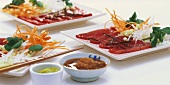 Platters of sashimi and shredded vegetables, Asian sauces