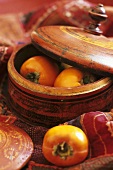 Fresh persimmons in a wooden bowl