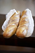 Two baguettes wrapped in paper