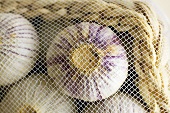 Garlic in a small basket covered by a net