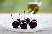 Chocolate-dipped cherries on a glass platter