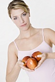 Junge Frau hält drei Äpfel in den Händen