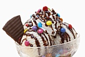 Ice cream sundae with chocolate sauce, Smarties & chocolate wafer
