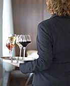 Kellner trägt ein Tablett mit verschiedenen Weinen in Gläsern