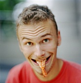 Young man eating a prawn tail