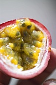 Hand holding half a passion fruit