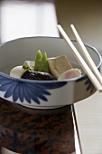 Gedämpftes Gemüse und Tofu in einer Schale mit Essstäbchen