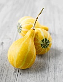 Three yellow gourds on grey wooden table