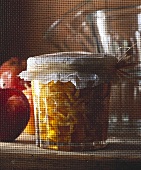 Caramelised apple preserve in a glass jar behind a fly screen