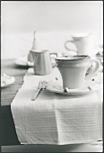 Kaffeegeschirr auf Frühstückstisch (schwarz-weiss-Aufnahme)