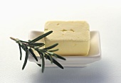 Fresh Butter in a White Butter Dish with Rosemary