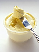 An Opened Container of Cream Cheese with Knife