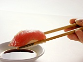 Chopsticks Holding Maguro Sushi Over Soy Sauce