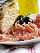 Salami mit Oliven, Rosmarin und Weißbrot; Olivenöl