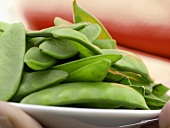 Snow Peas in a Dish Being Held