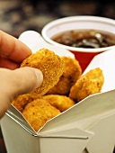 Chicken Nugget aus Fast-Food-Box nehmen