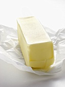 Unwrapped Stick of Butter Resting on Wrapper