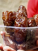Holding Wrapped Dates in a Plastic Container
