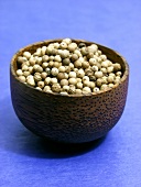 White peppercorns in brown bowl