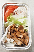 Döner kebab with vegetables in aluminium dish