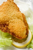 Fish nugget with lettuce leaf and slice of lemon