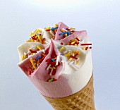 Strawberry and vanilla ice cream with sprinkles in cone