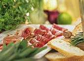 Platter of salami and ham with slices of white bread