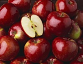 Ganze rote Äpfel mit einer Apfelhälfte